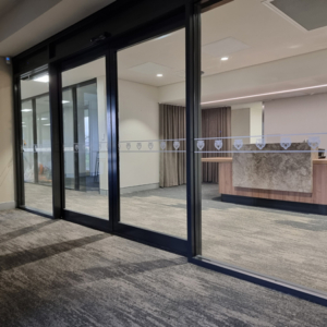 A strip of window decals along glass office doors and windows. The decals are the tiger head icon of the East Tigers Football Club logo.