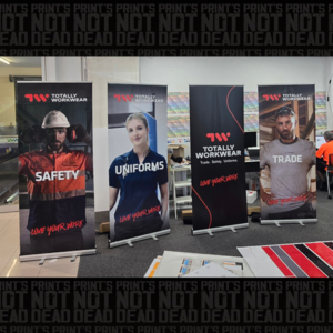 Four pull up banners on display for Totally Workwear. Each with different branded messages and image of an individual tradesperson.