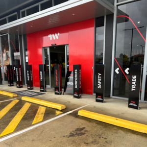 A Totally Workwear shop front with several branded bollard covers in place