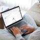 Person sitting on couch, reading a Signosaur EDM from their laptop