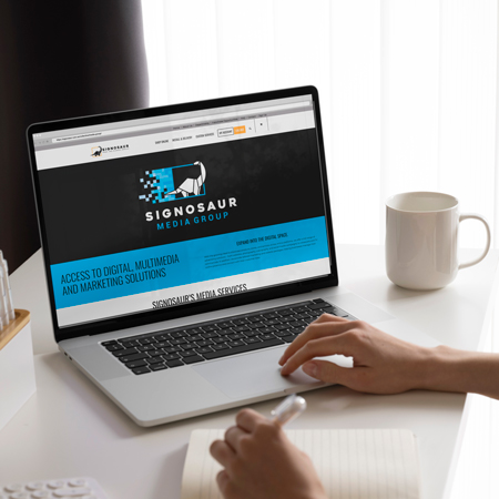 Person using a laptop with Signosaur's Media Group landing page open